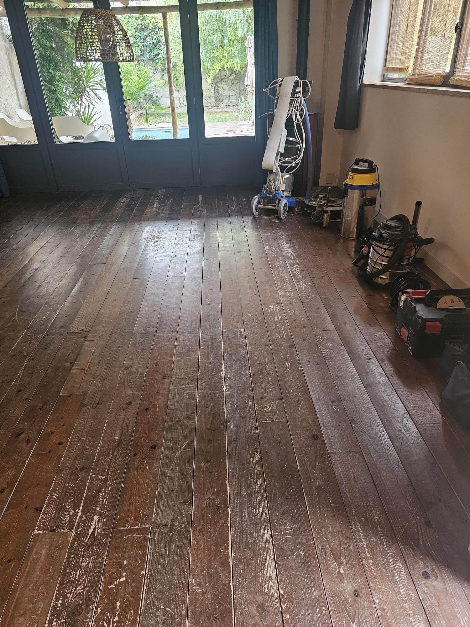 Loft après rénovation : plancher pin blanc naturel, briques et charpente apparentes